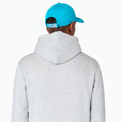 New Era Charlotte Hornets NBA Grey Pullover Hoodie, rear view showing the light grey hood against the back, worn by a person in a blue cap with an embossed Hornets logo on the adjustable strap.