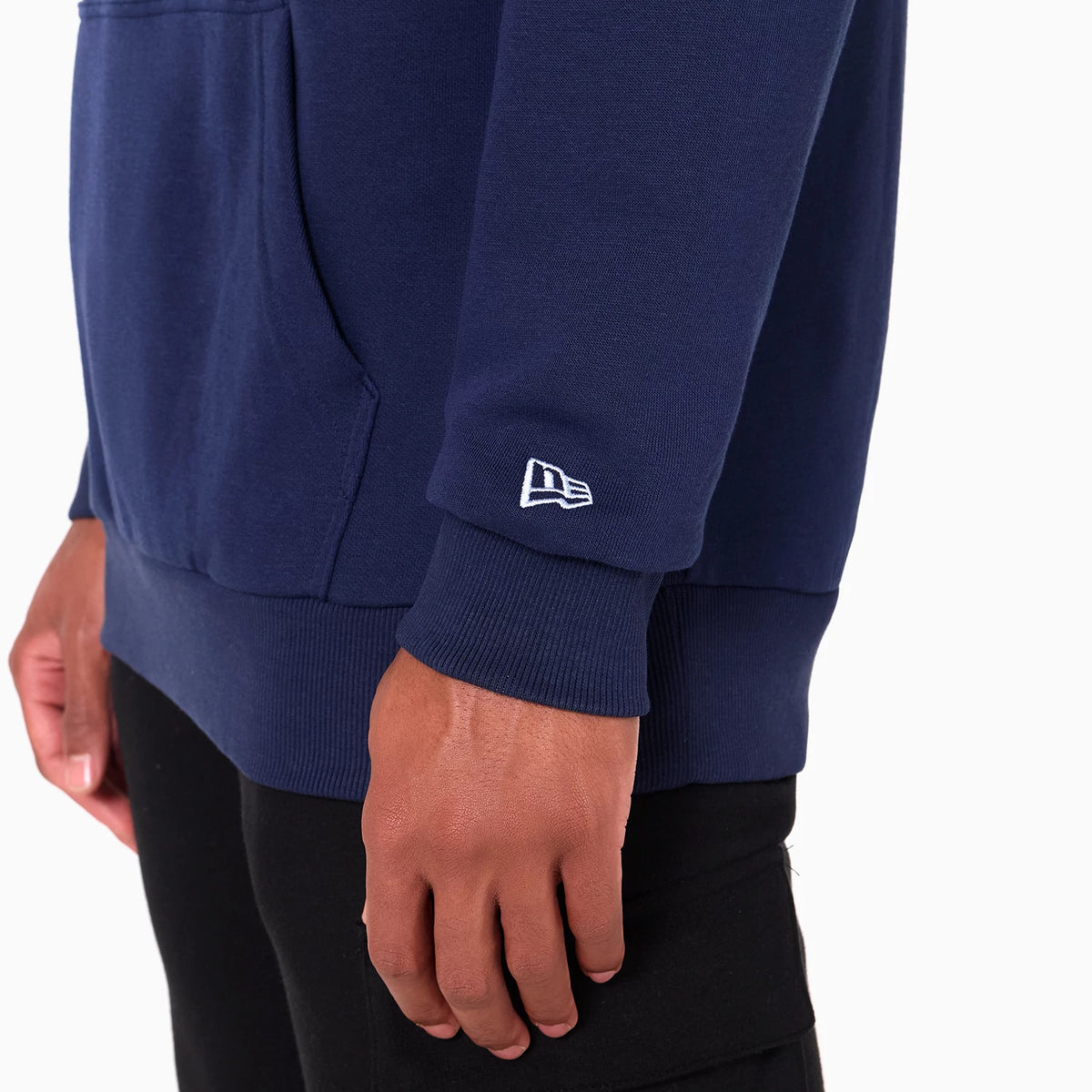 New Era Memphis Grizzlies NBA Navy Pullover Hoodie, side view showing the ribbed cuffs of the navy sleeve with a raised white New Era logo near the wrist and a kangaroo pocket at the front.