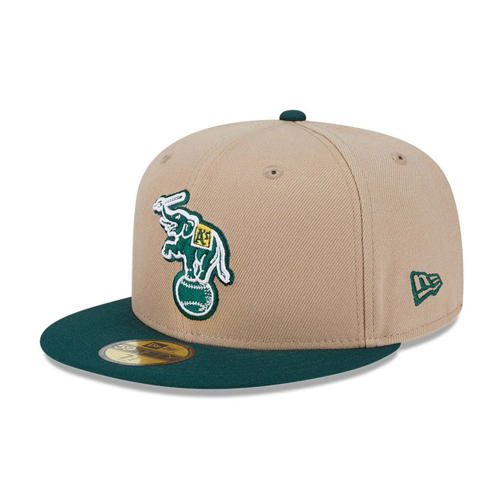 Athletics MLB Evergreen Light Beige New Era 59FIFTY Fitted Cap, three-quarter view with the green embroidered elephant logo on the front panel, dark green visor with gold 59FIFTY size sticker, and New Era flag logo on the left side.