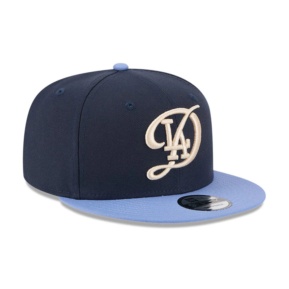 LA Dodgers MLB Evergreen Dark Blue New Era 9FIFTY Snapback Adjustable Cap, three-quarter view showing cream LA logo embroidery on the front panel, light blue visor, and black 9FIFTY size sticker on top.