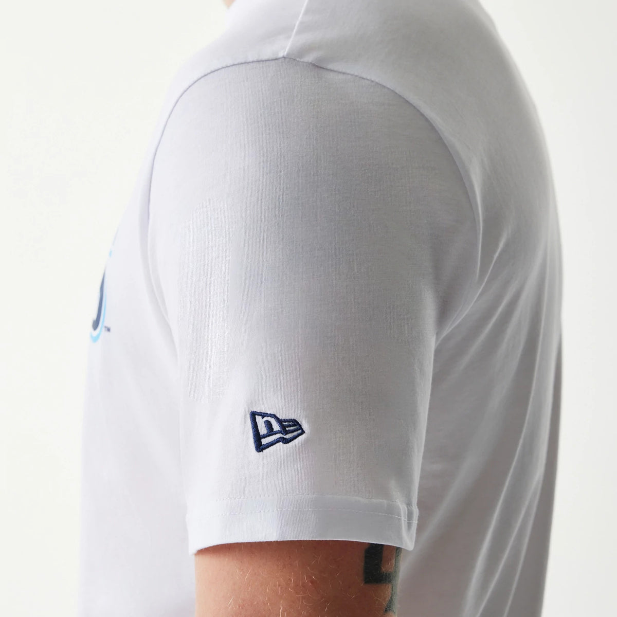 New Era Tampa Bay Rays MLB Regular White T-Shirt, side view showing the short sleeve with a raised New Era logo embroidered near the hem, a glimpse of a light blue design on the chest, and a crew neckline on a white cotton shirt.