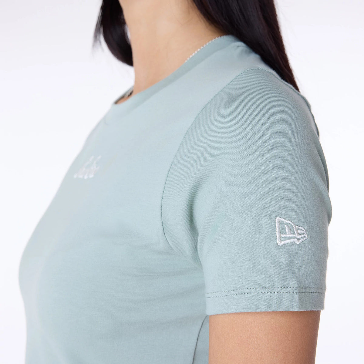 Womens New Era Slim Pastel Blue T-Shirt, side view showing a light blue short-sleeved tee with a white embroidered New Era logo on the sleeve and a small white embroidered logo on the chest.
