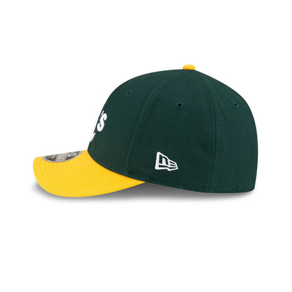 Athletics MLB Player Replica Dark Green New Era 9FORTY M-Crown Adjustable Cap, side view showing the white New Era flag logo on the left side of the structured dark green crown with a contrasting yellow visor and 9FORTY size sticker.