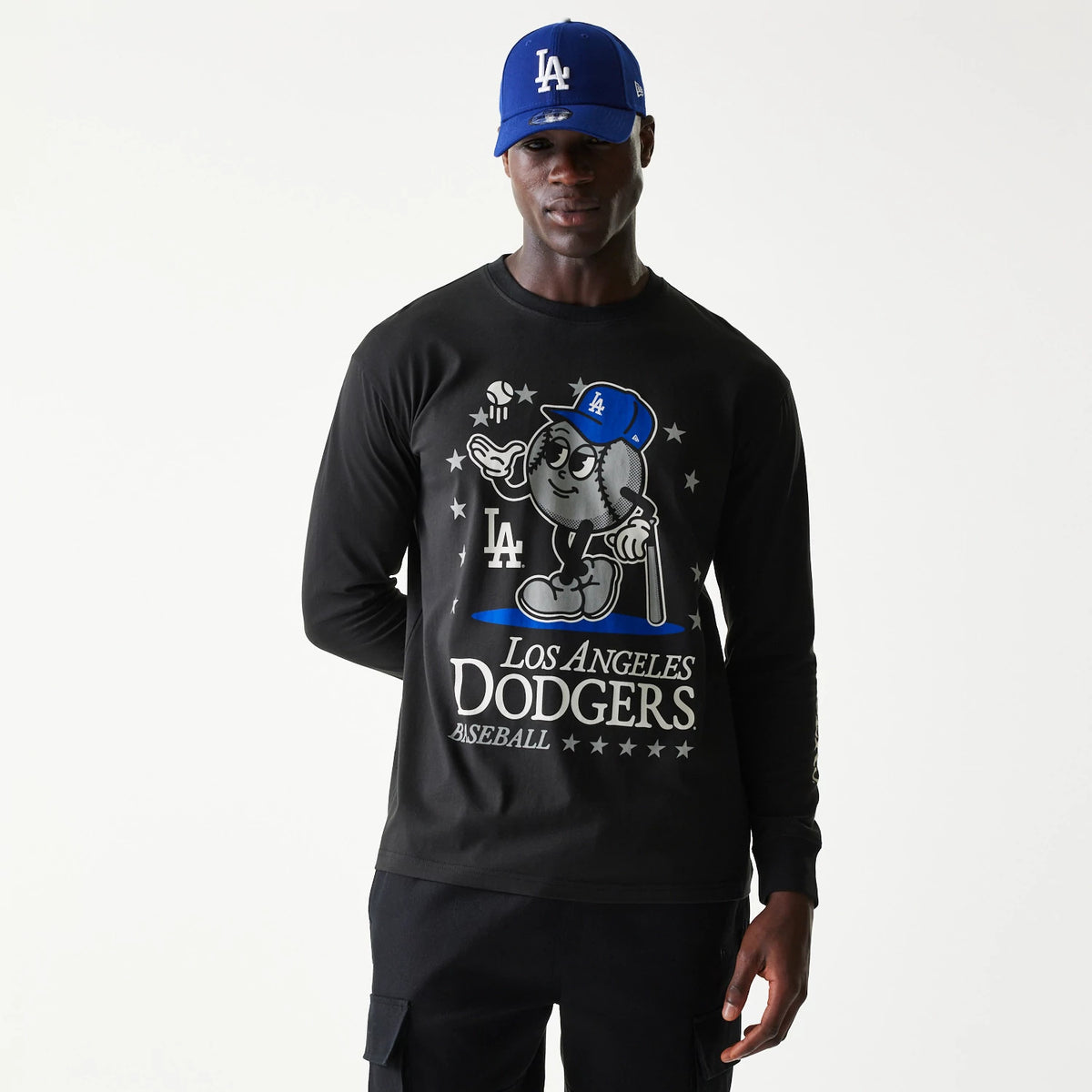 New Era LA Dodgers MLB Character Black Long Sleeve T-Shirt, on-model view showing the large character graphic on the chest featuring a baseball figure with a blue cap, LA logo on the left, and Los Angeles Dodgers text below in stylised font.