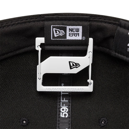 New Era White Cap Clip, inside view with the clip attached to the black taping of a 59FIFTY cap, displaying the New Era flag logo on the white clip and the inner branded taping with black stitching.