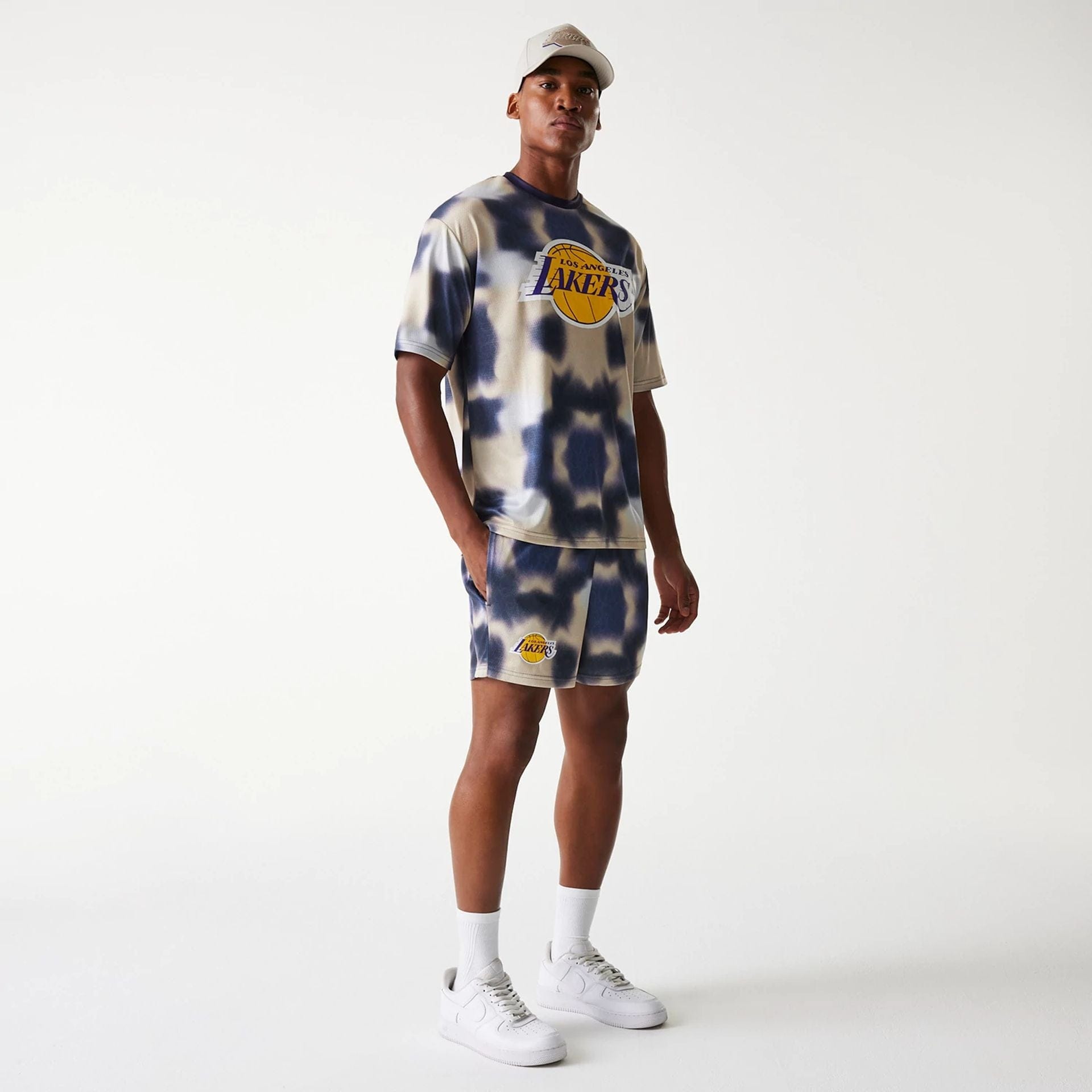 The Male model is wearing LA Lakers NBA All Over Print Cream Shorts 8