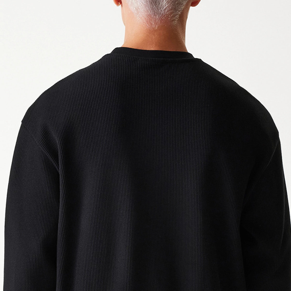 New Era Waffle Black Oversized Crew Neck Sweater, rear view on a model showcasing the textured waffle knit pattern and relaxed fit across the shoulders and back.