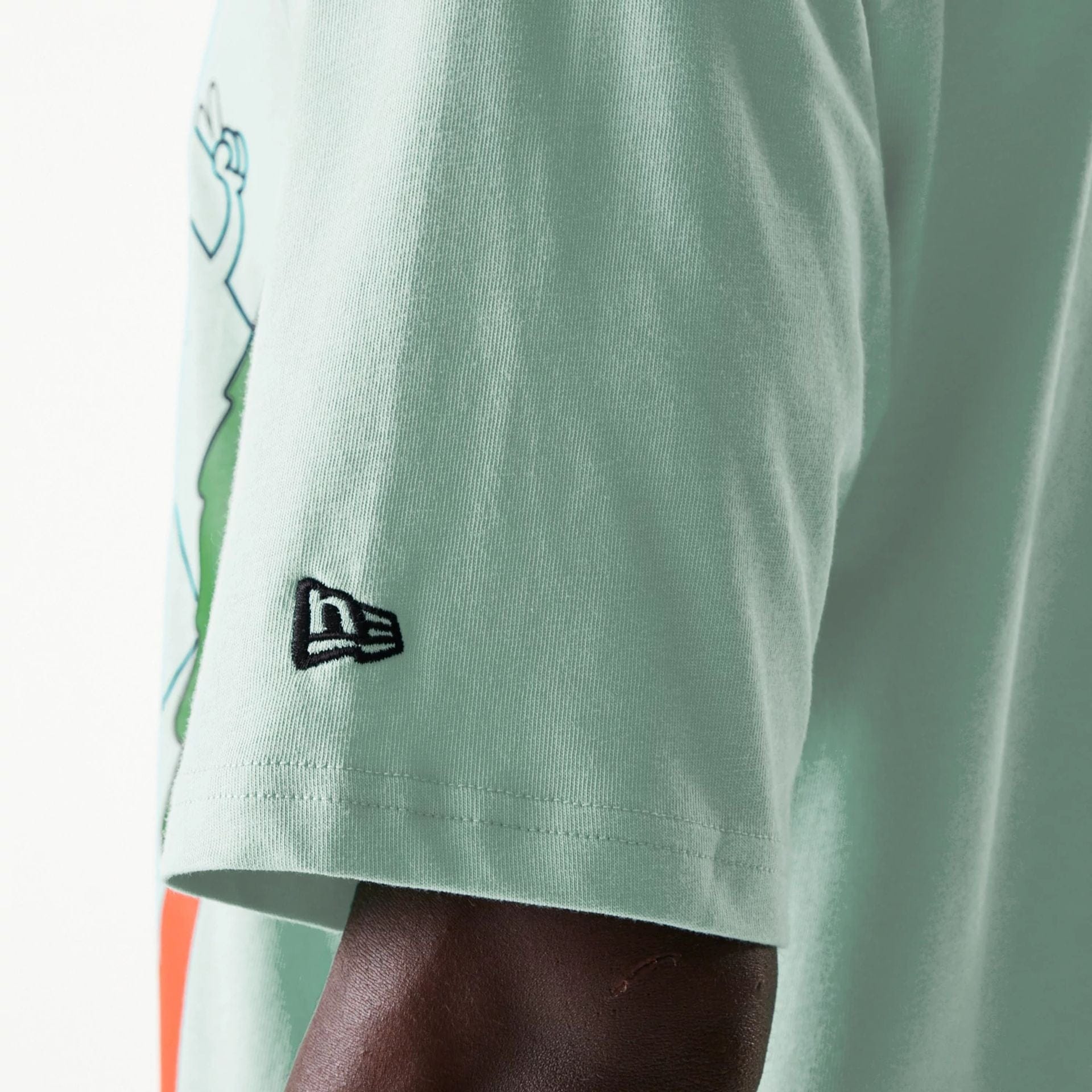 The Male model is wearing New Era Outdoor Graphic Pastel Green Oversized T-Shirt 5