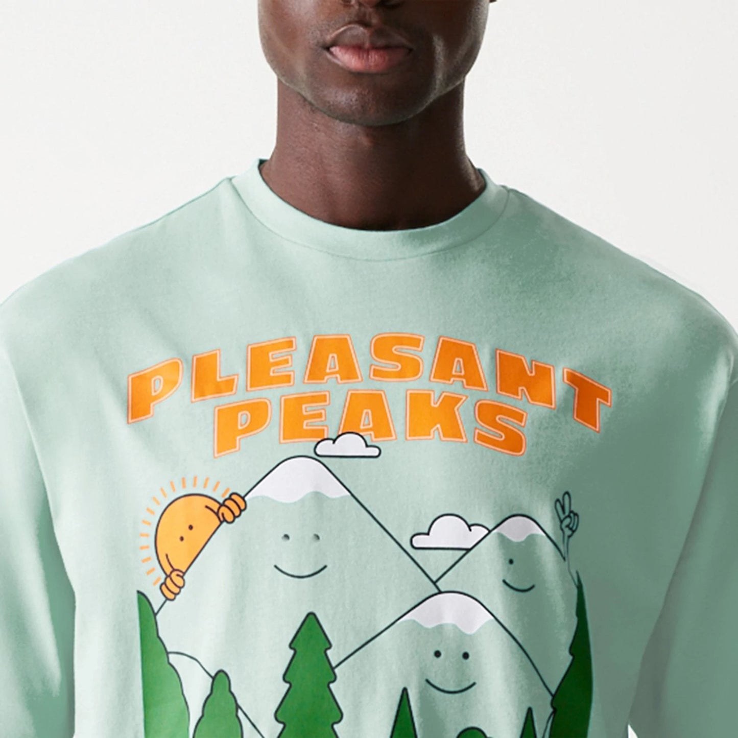 The Male model is wearing New Era Outdoor Graphic Pastel Green Oversized T-Shirt 6