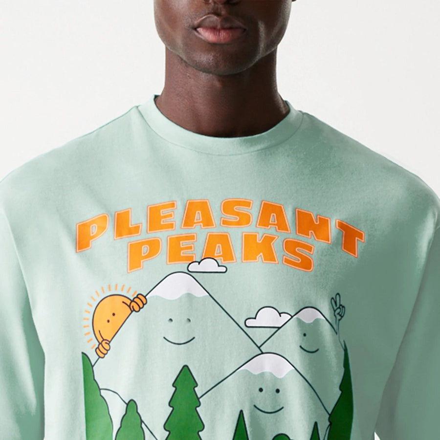 The Male model is wearing New Era Outdoor Graphic Pastel Green Oversized T-Shirt 6