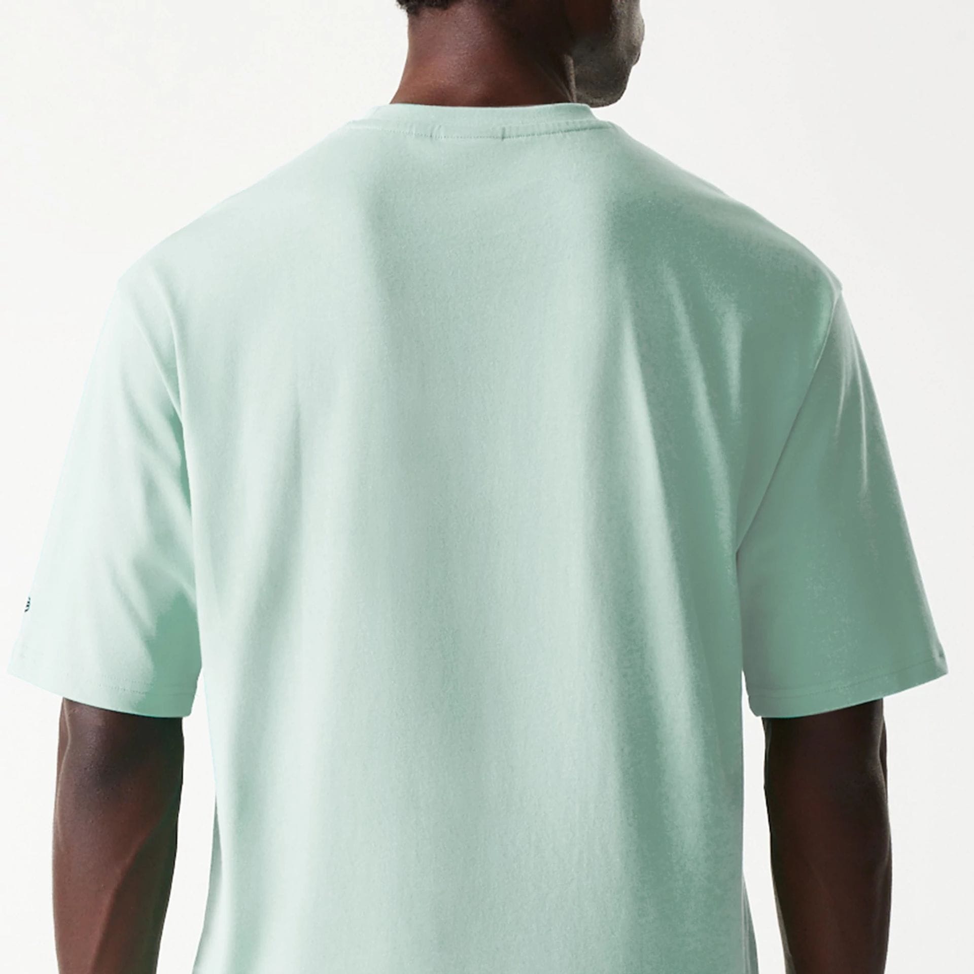 The Male model is wearing New Era Outdoor Graphic Pastel Green Oversized T-Shirt 7