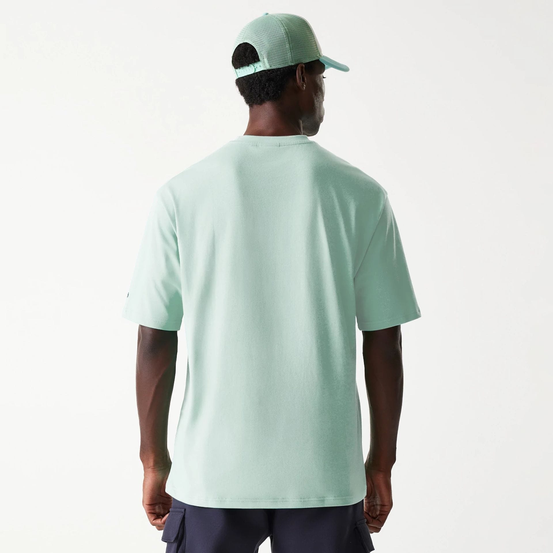The Male model is wearing New Era Outdoor Graphic Pastel Green Oversized T-Shirt 2