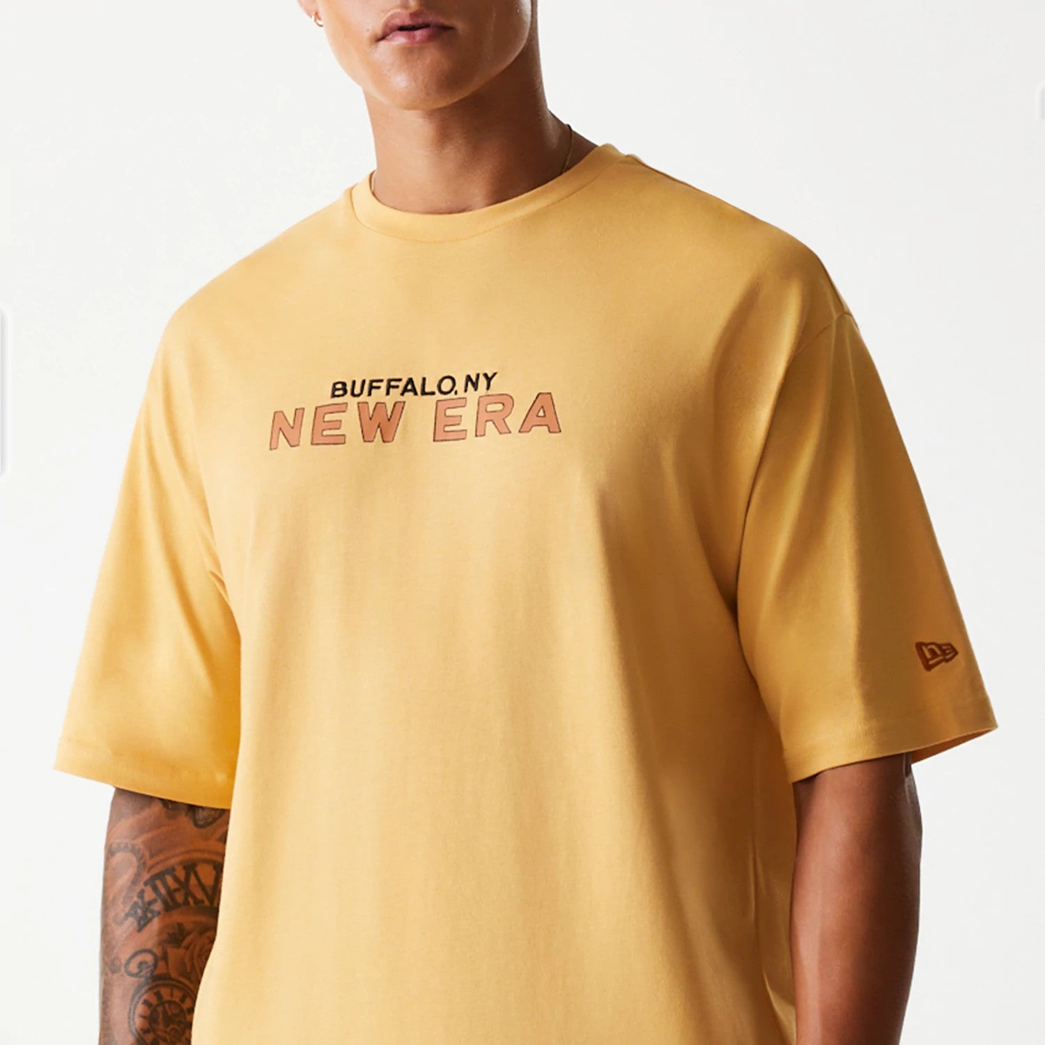 The Male model is wearing New Era Vacation Graphic Beige Oversized T-Shirt 3