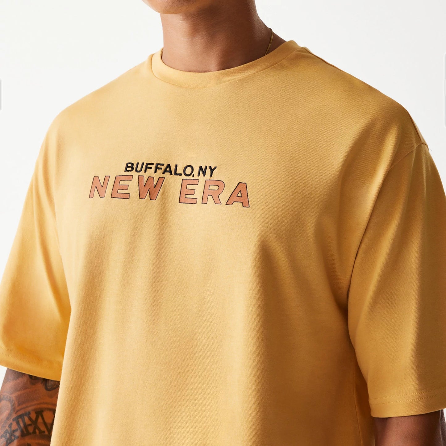 The Male model is wearing New Era Vacation Graphic Beige Oversized T-Shirt 5