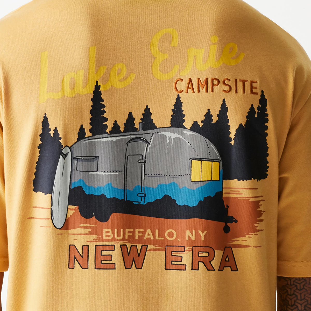 New Era Vacation Graphic Beige Oversized T-Shirt, rear view showing an illustrated campervan graphic with trees and text reading Lake Erie Campsite above and Buffalo, NY with New Era below, against a beige background.