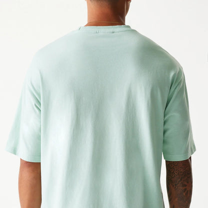 The Male model is wearing New Era Crest Pastel Green Oversized T-Shirt 7