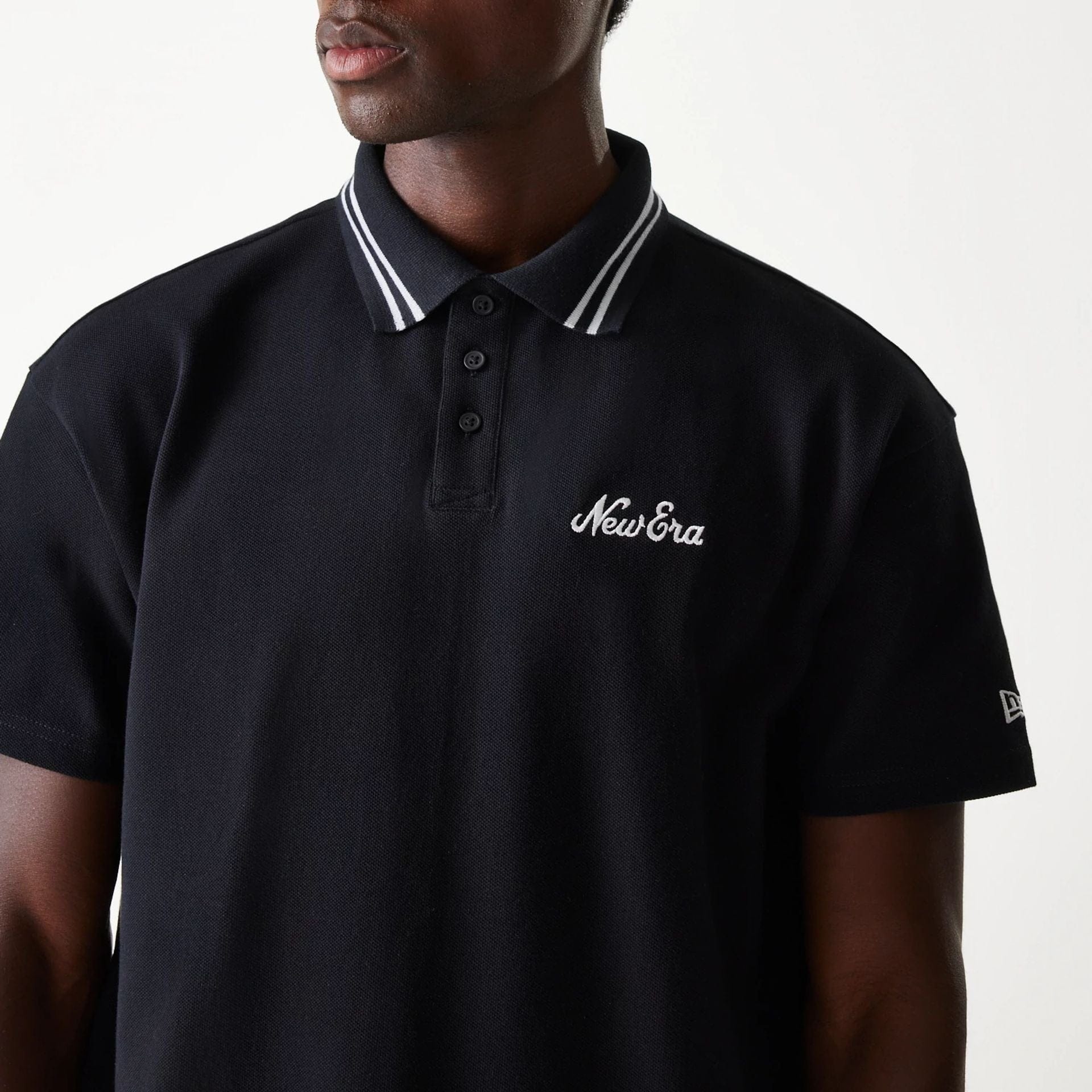 The Male model is wearing New Era Drop Shoulder Black Polo Shirt 3