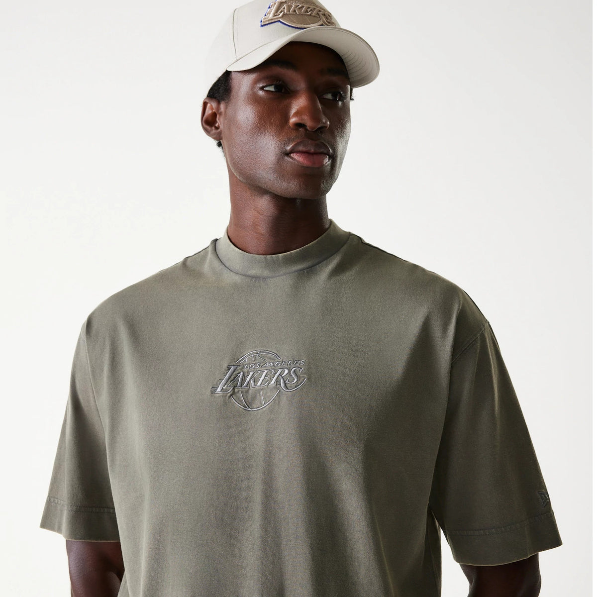 New Era LA Lakers NBA Washed Grey Box T-Shirt, on-model view showing the faded grey fabric with a raised Lakers logo centred on the chest, short sleeves, and a New Era logo embroidered on the left sleeve.