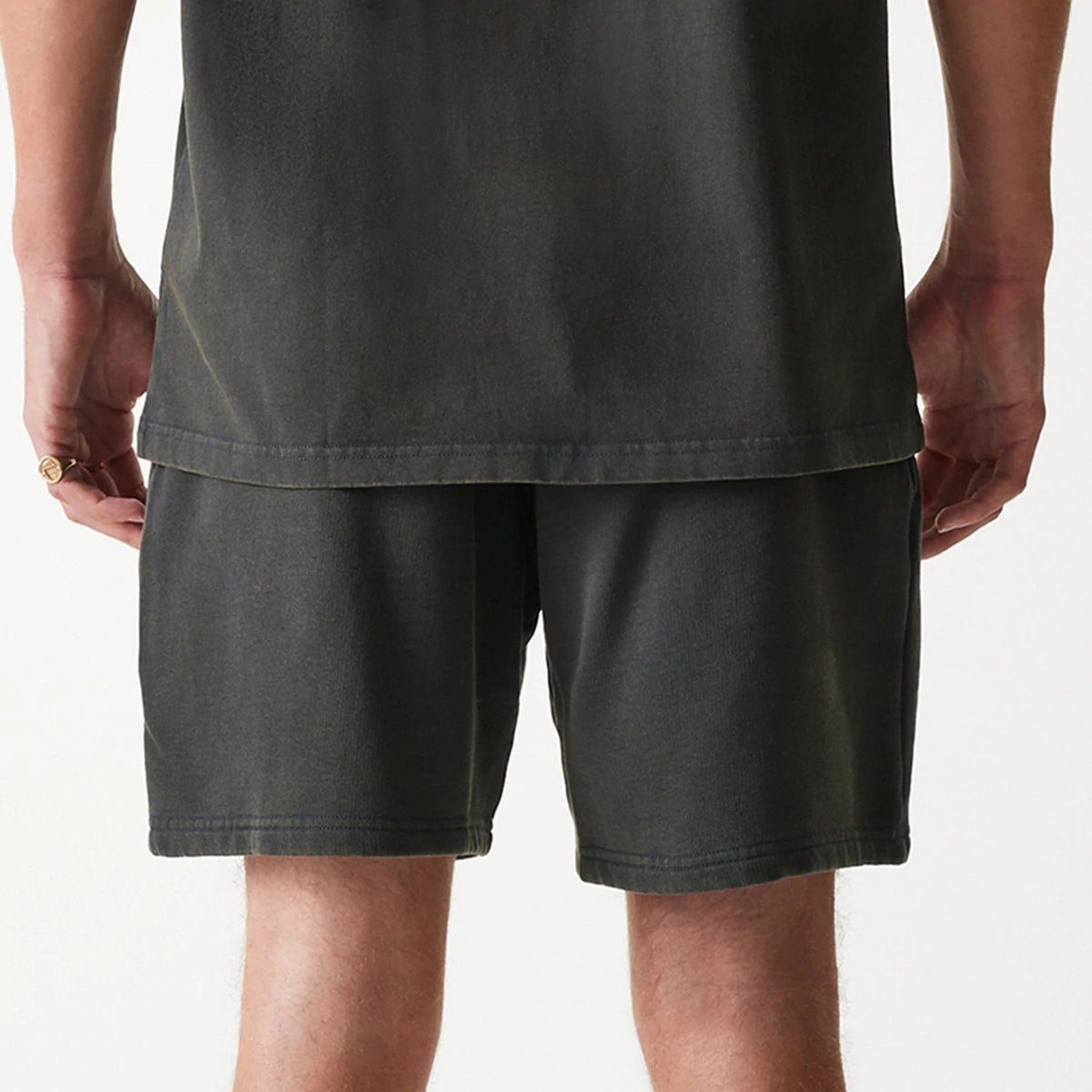 New Era Chicago Bulls NBA Washed Grey Shorts, rear view showing a washed dark grey colour with a straight hem, worn by a model standing with arms at sides, shirt hanging over the waistband.