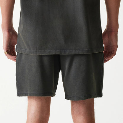 New Era Chicago Bulls NBA Washed Grey Shorts, rear view showing a washed dark grey colour with a straight hem, worn by a model standing with arms at sides, shirt hanging over the waistband.