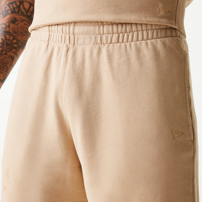 New Era Chicago Bulls NBA Washed Beige Shorts, front view showing the elastic waistband and two debossed logos, one on the right leg near the pocket and another at the hem on the left.