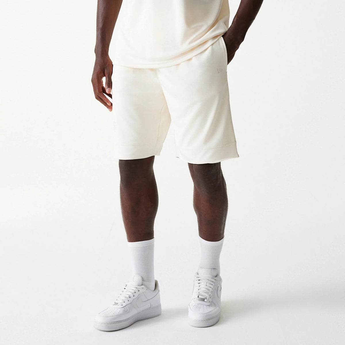 New Era LA Lakers NBA Tonal Open White Mesh Shorts, on-model view showing white knee-length shorts with a relaxed fit, an embossed logo on the left thigh, and side pockets.