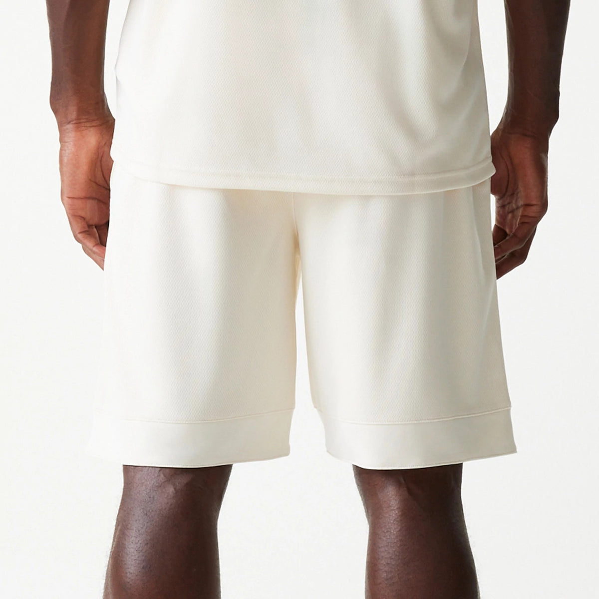New Era LA Lakers NBA Tonal Open White Mesh Shorts, rear view showing the plain white mesh fabric, loose fit with a wide waistband, and the hems falling just above the knee.