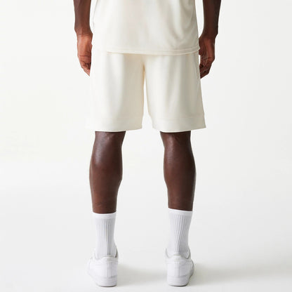 New Era LA Lakers NBA Tonal Open White Mesh Shorts, rear view showing the plain white shorts with a loose fit just above the knee, straight hem, and white socks paired with white shoes visible below.