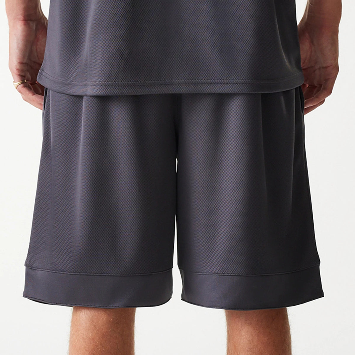 New Era Chicago Bulls NBA Tonal Dark Grey Mesh Shorts, rear view showing the dark grey mesh with a smooth elastic waistband and loose fit, the shorts reaching down to the knees, and a plain hem without visible logos.
