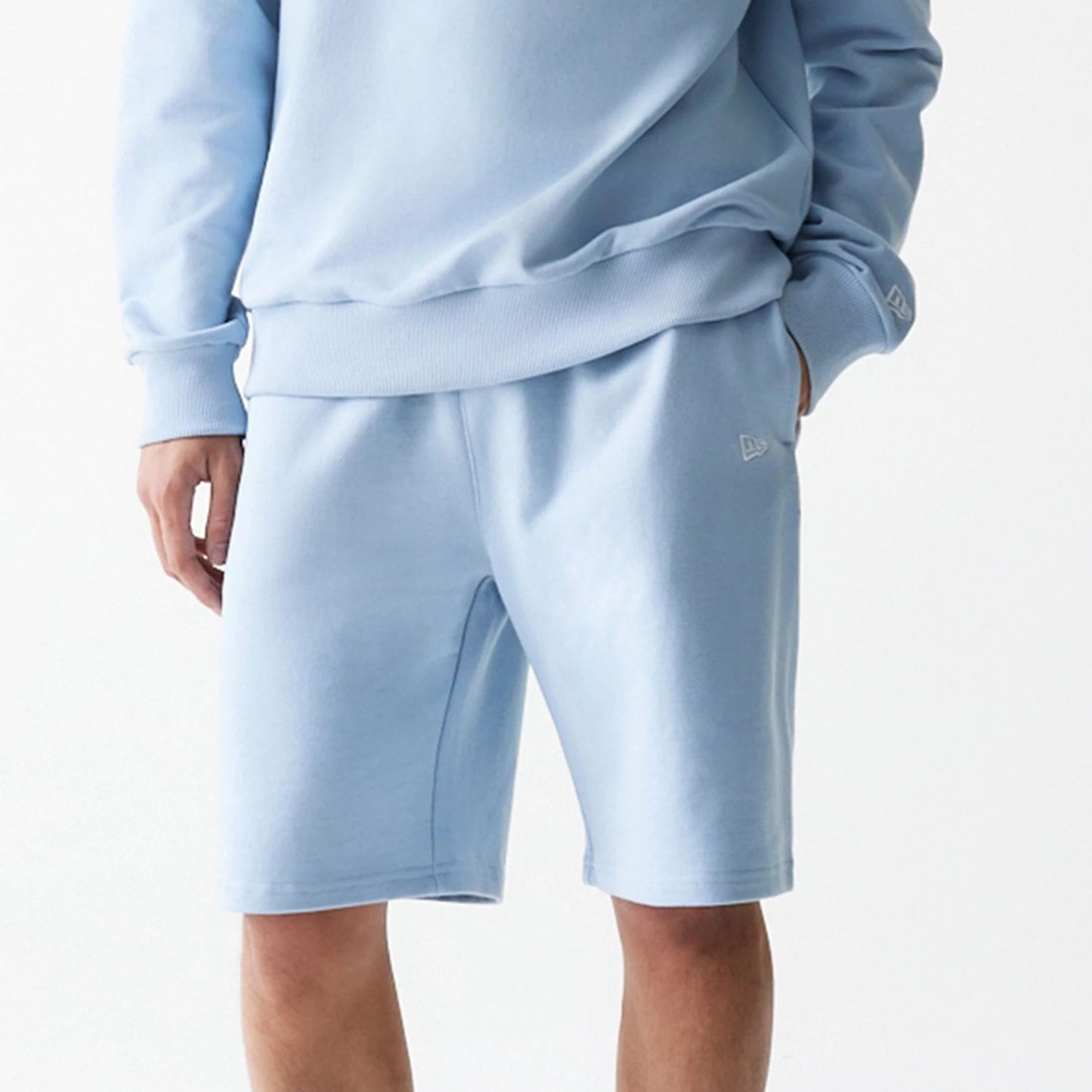 The Male model is wearing New Era Pastel Blue Oversized One Panel Shorts 3