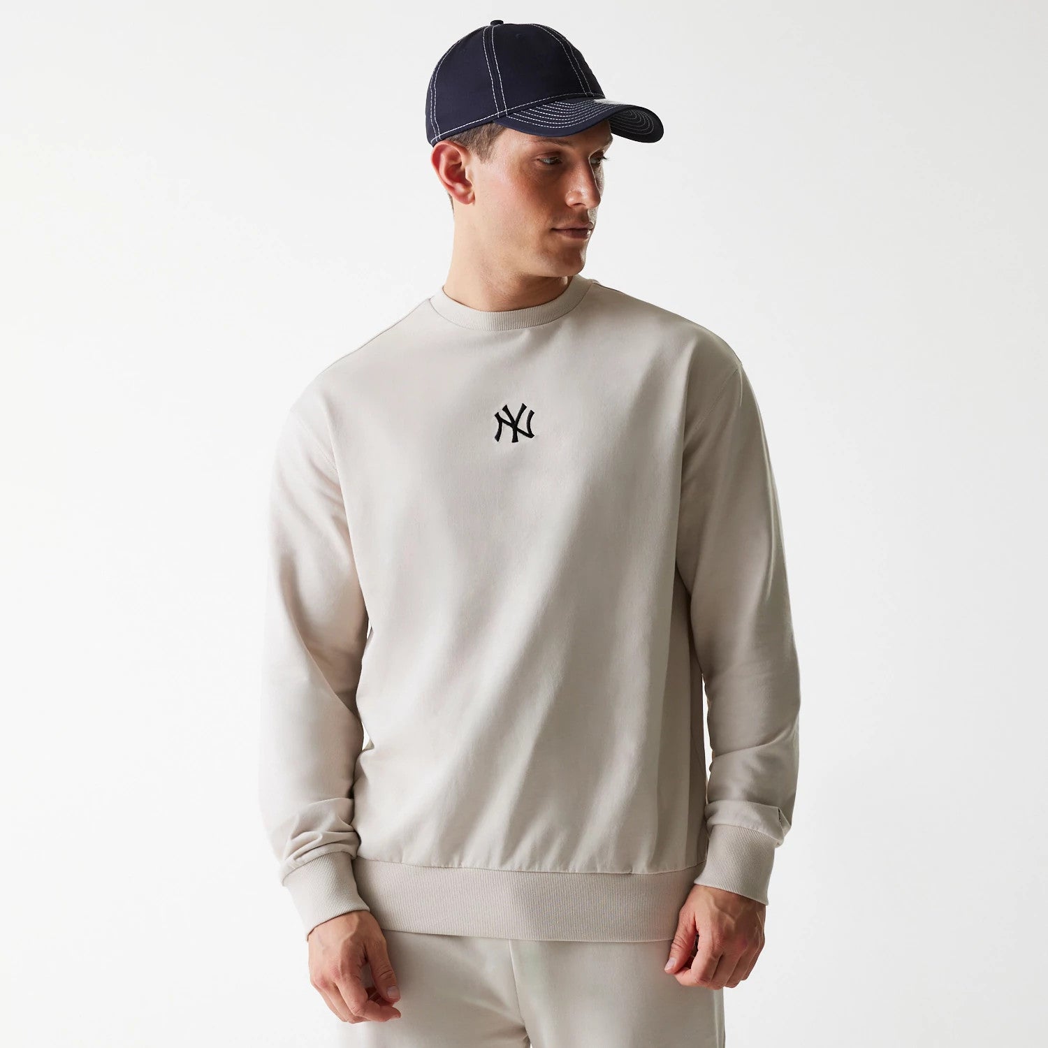 The Male model is wearing New York Yankees MLB League Essential Cream Crew Neck Sweater 1