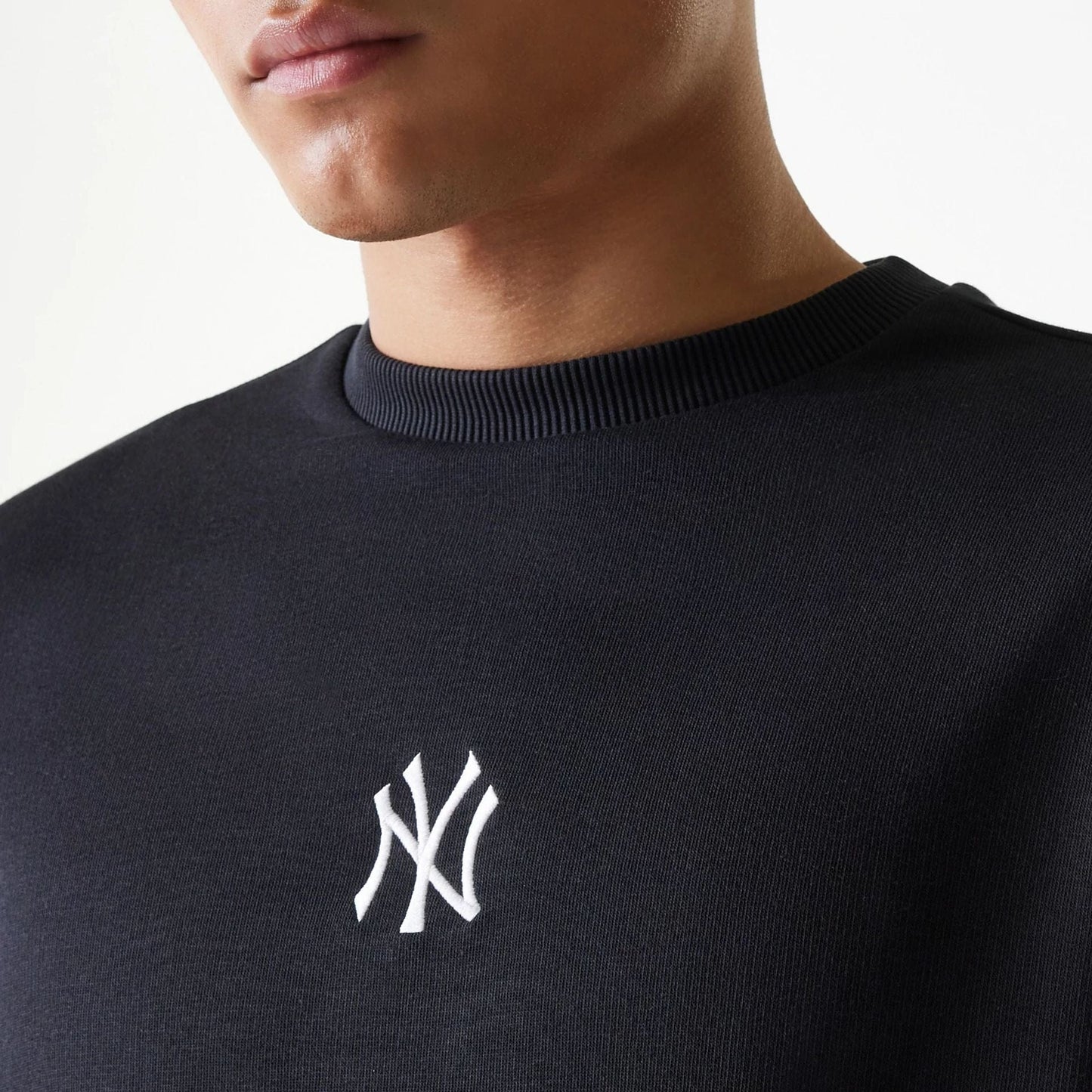The Male model is wearing New York Yankees MLB League Essential Black Crew Neck Sweater 4