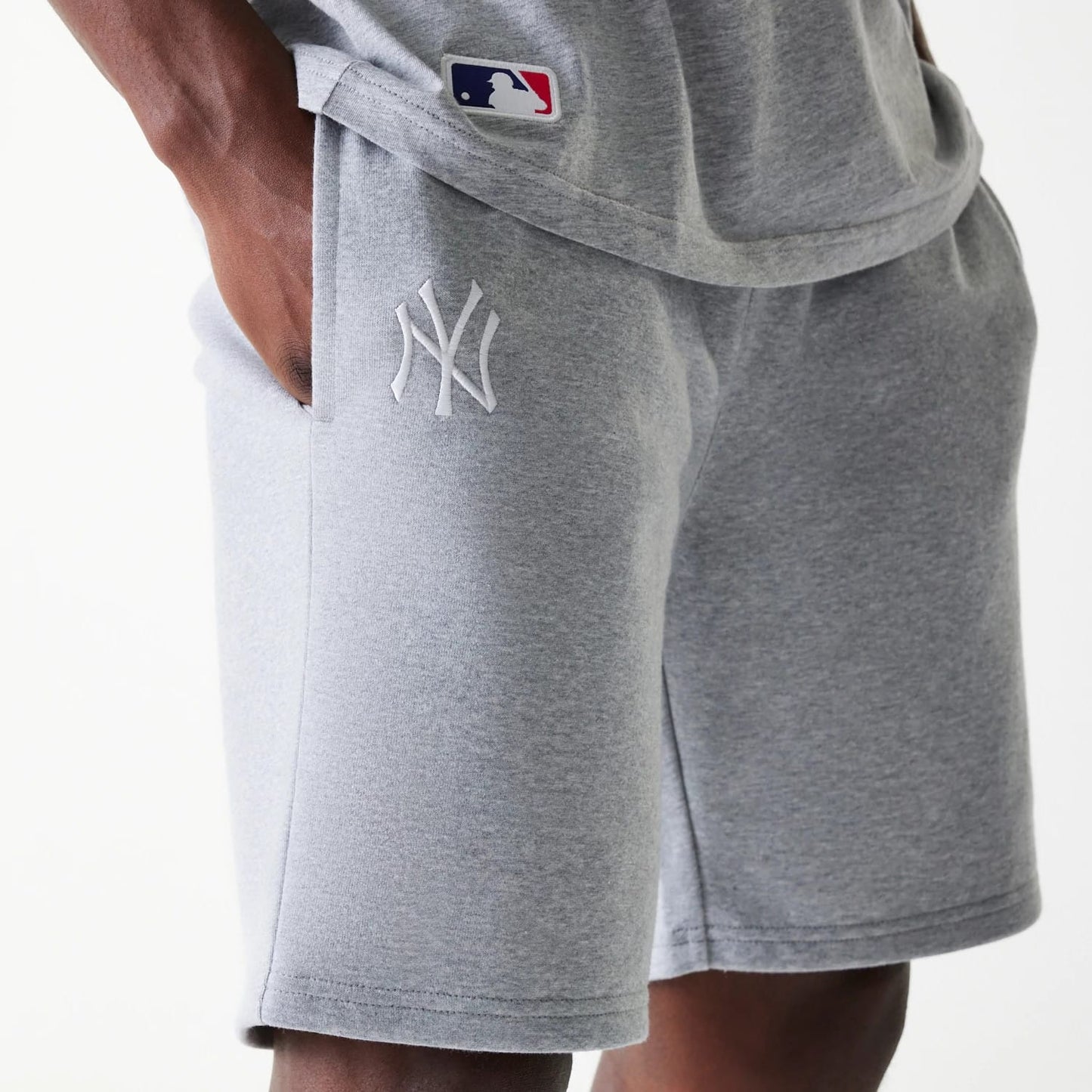The Male model is wearing New York Yankees MLB League Essential Grey Shorts 4