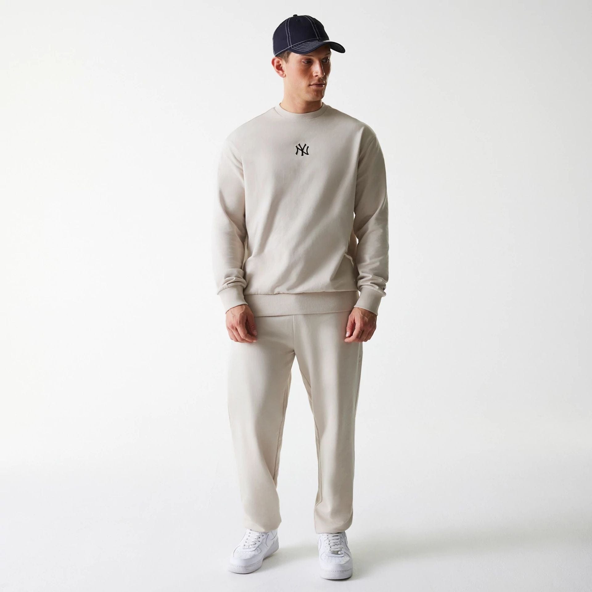 The Male model is wearing New York Yankees MLB League Essential Midi Cream Joggers 8