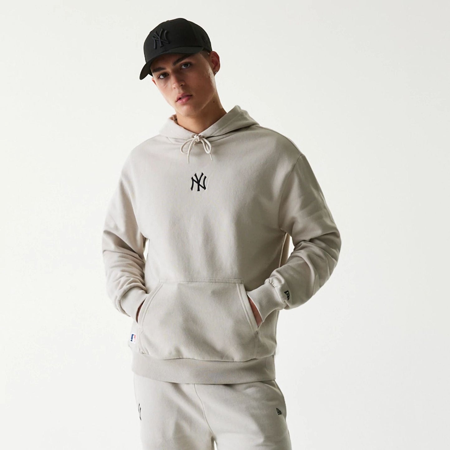 The Male model is wearing New York Yankees MLB League Essential Cream Oversized Pullover Hoodie 3