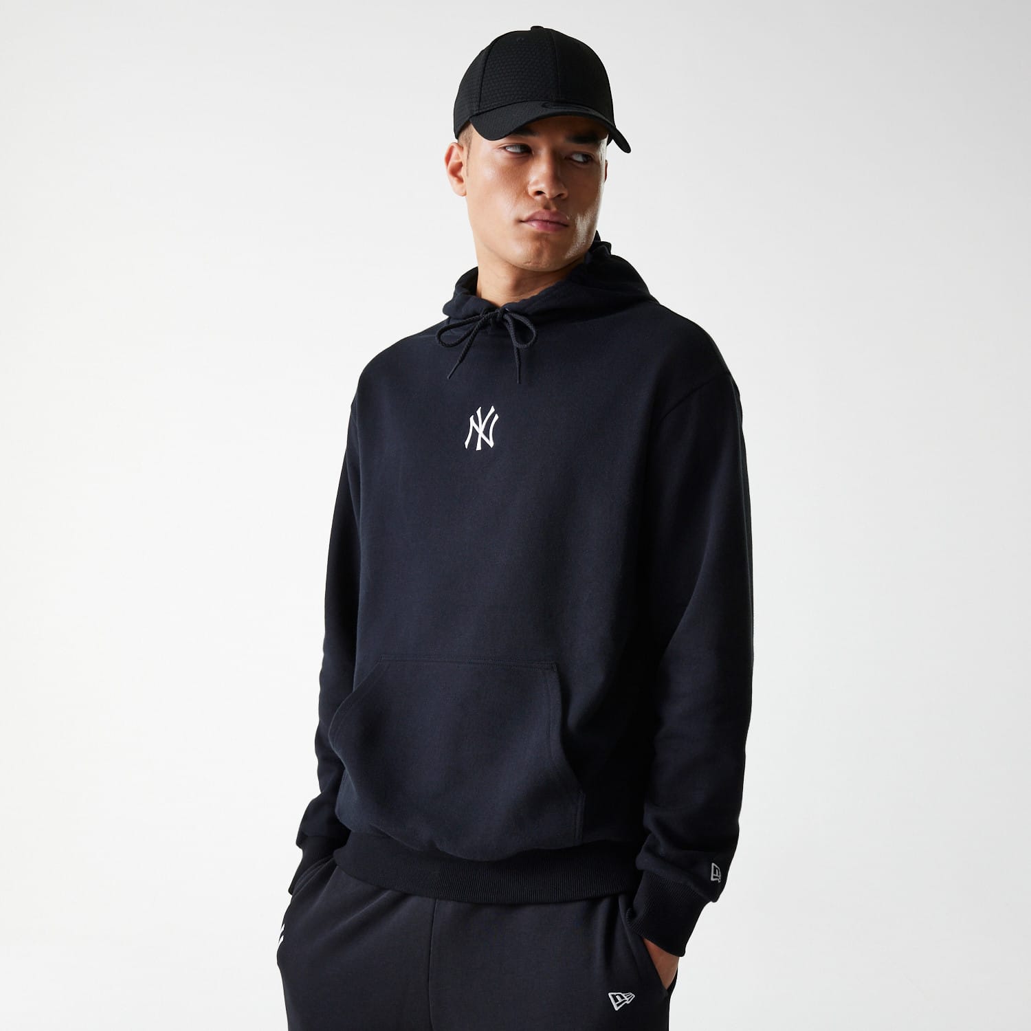 The Male model is wearing New York Yankees MLB League Essential Black Oversized Pullover Hoodie 1