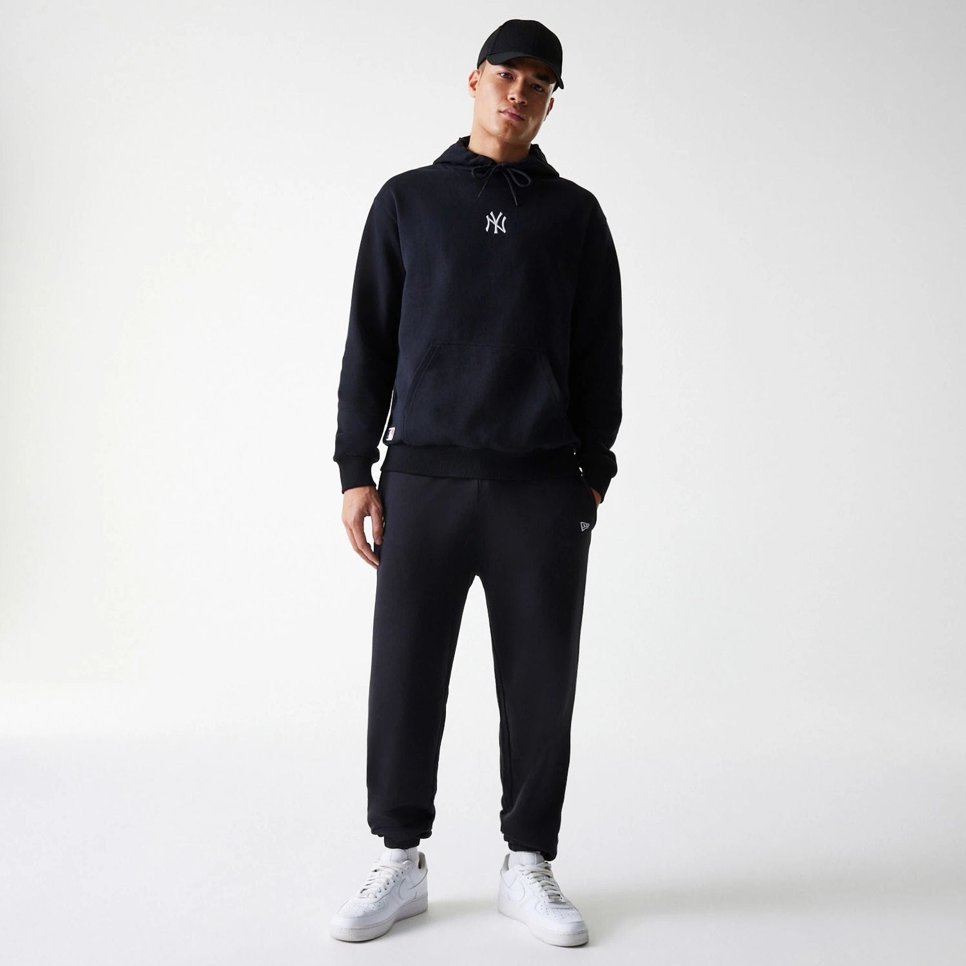 The Male model is wearing New York Yankees MLB League Essential Black Oversized Pullover Hoodie 7
