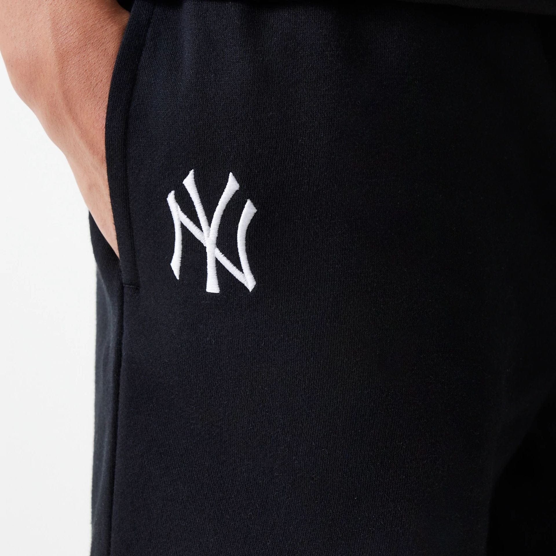 The Male model is wearing New York Yankees MLB League Essential Midi Black Shorts 4