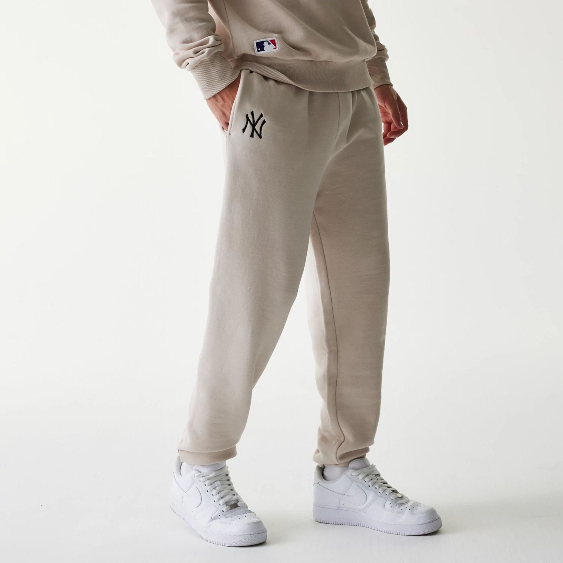 The Male model is wearing New York Yankees MLB League Essential Cream Joggers 1