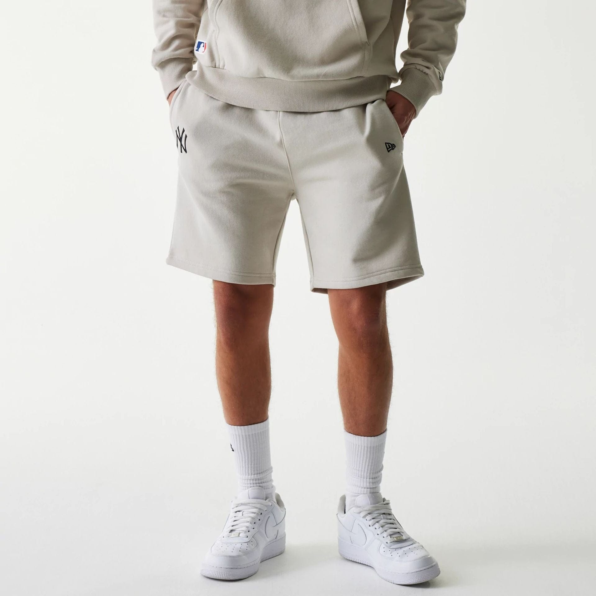 The Male model is wearing New York Yankees MLB League Essential Midi Cream Shorts 1