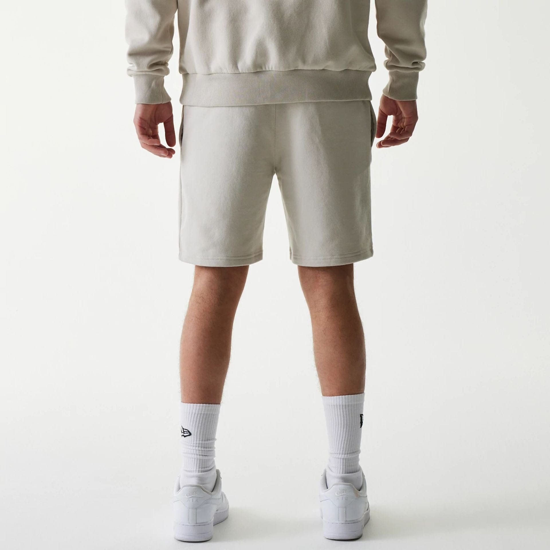 The Male model is wearing New York Yankees MLB League Essential Midi Cream Shorts 2