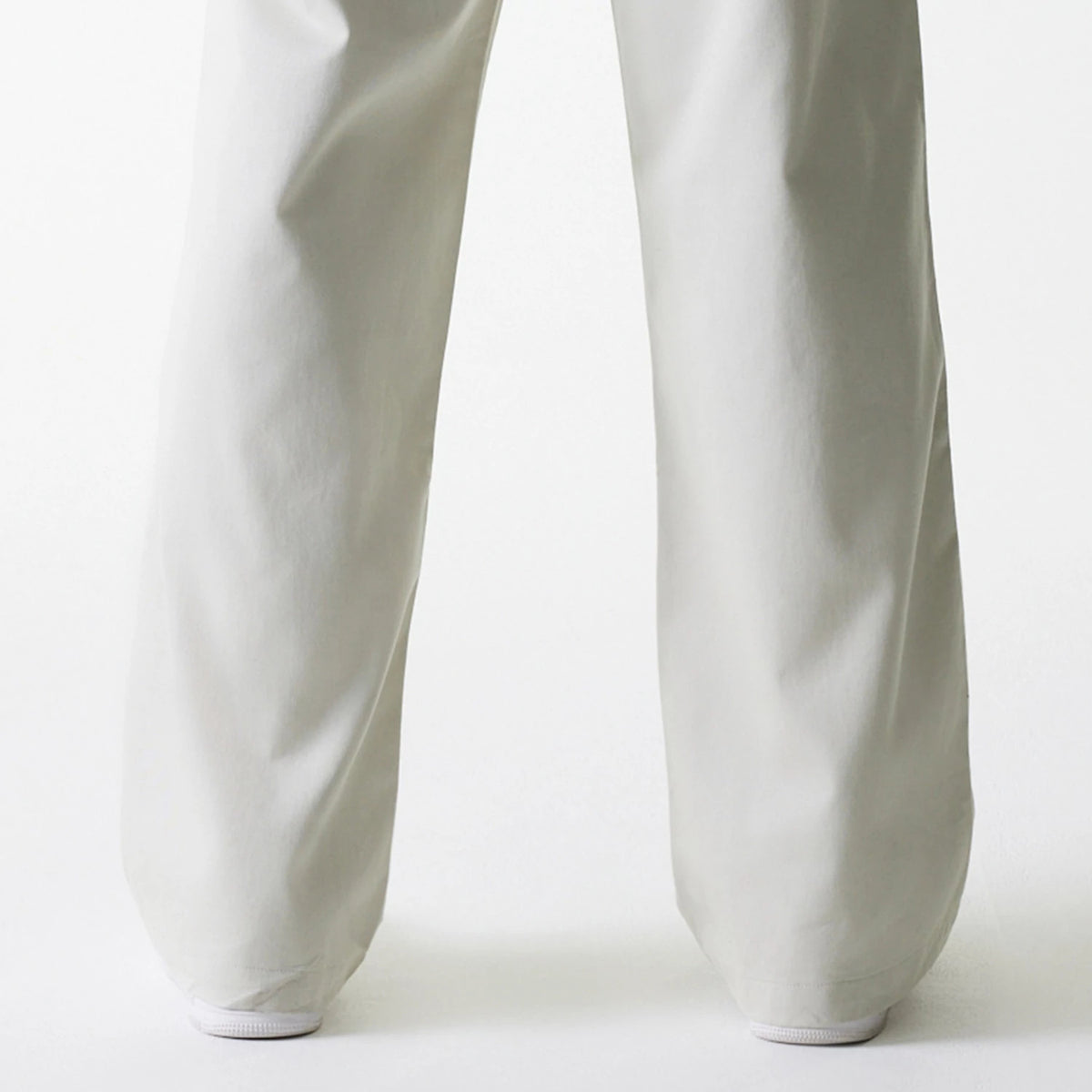 New Era New York Yankees MLB Light Beige Chino Trousers, front view showing the wide-leg design and full-length cut over white sneakers, emphasising the clean and crisp fabric appearance.