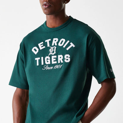 New Era Detroit Tigers MLB Heritage Dark Green Oversized T-Shirt, front view showing large white text across the chest with the team logo in the centre, and a small New Era logo tag on the sleeve.