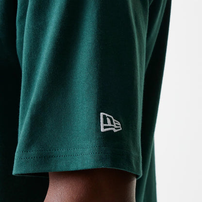 New Era Detroit Tigers MLB Heritage Dark Green Oversized T-Shirt, side view showing a close-up of the sleeve with a raised white New Era logo embroidered near the hem on the dark green fabric.