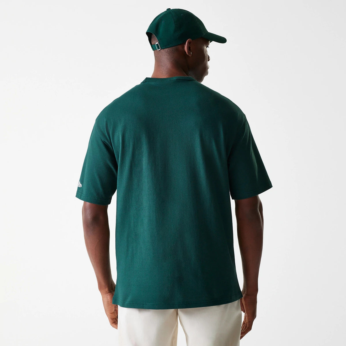 New Era Detroit Tigers MLB Heritage Dark Green Oversized T-Shirt, rear view showing the plain dark green back with short sleeves, a small New Era logo embroidered in white on the left sleeve, paired with a matching dark green cap.