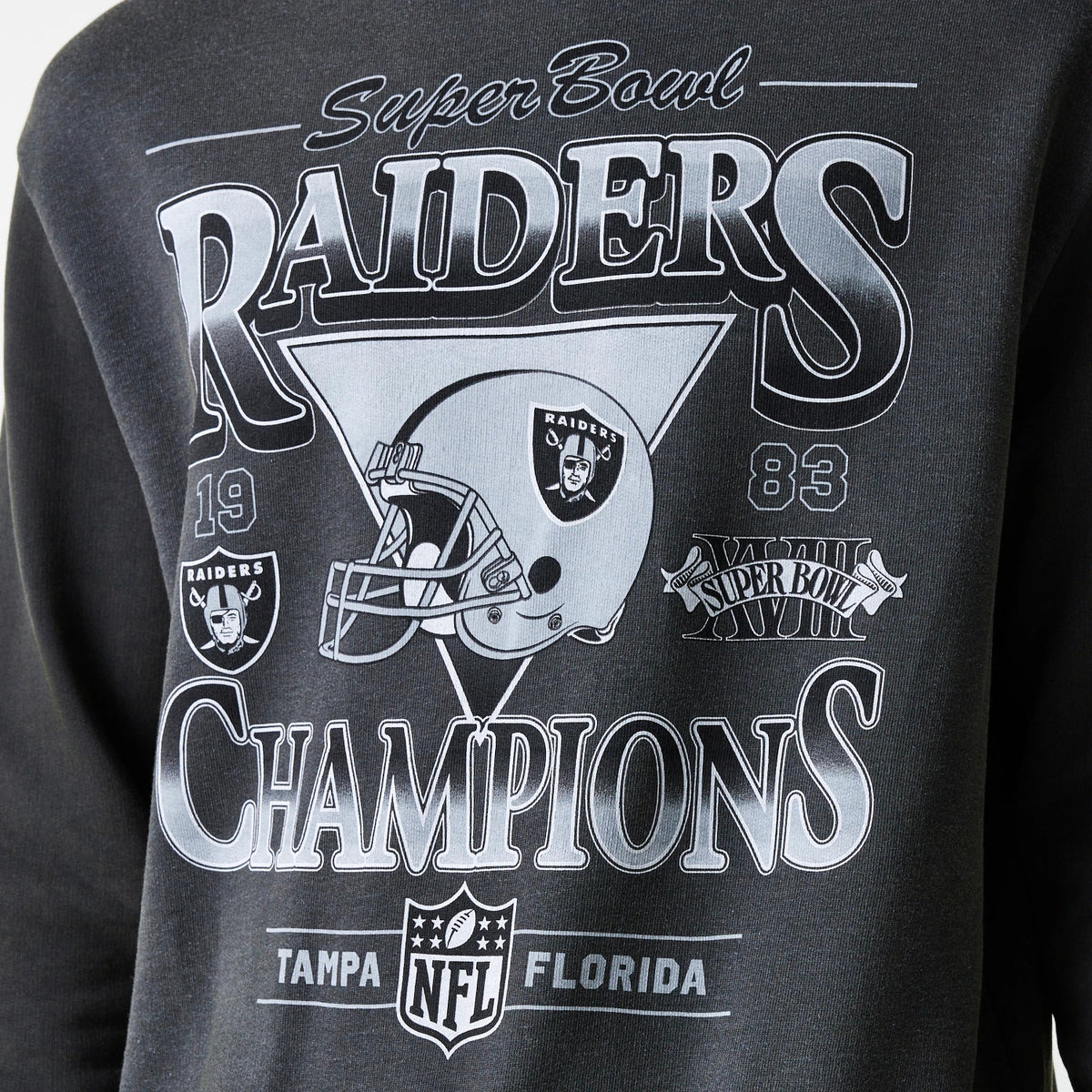 New Era Las Vegas Raiders NFL Washed Super Bowl Grey Oversized Crew Neck Sweater, close-up showing vintage Super Bowl graphics with Raiders helmet and Champions lettering on the chest, detailed with 1983 and location markers.