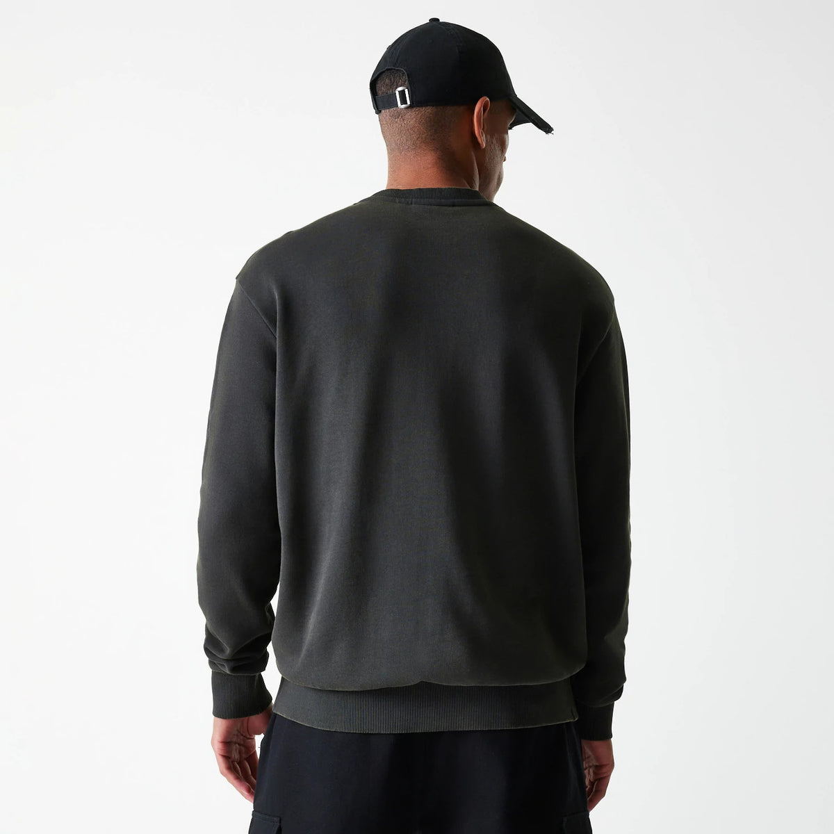 New Era Las Vegas Raiders NFL Washed Super Bowl Grey Oversized Crew Neck Sweater, rear view on a model with a black cap, showing the relaxed fit and ribbed waistband, highlighting the simplistic back design.