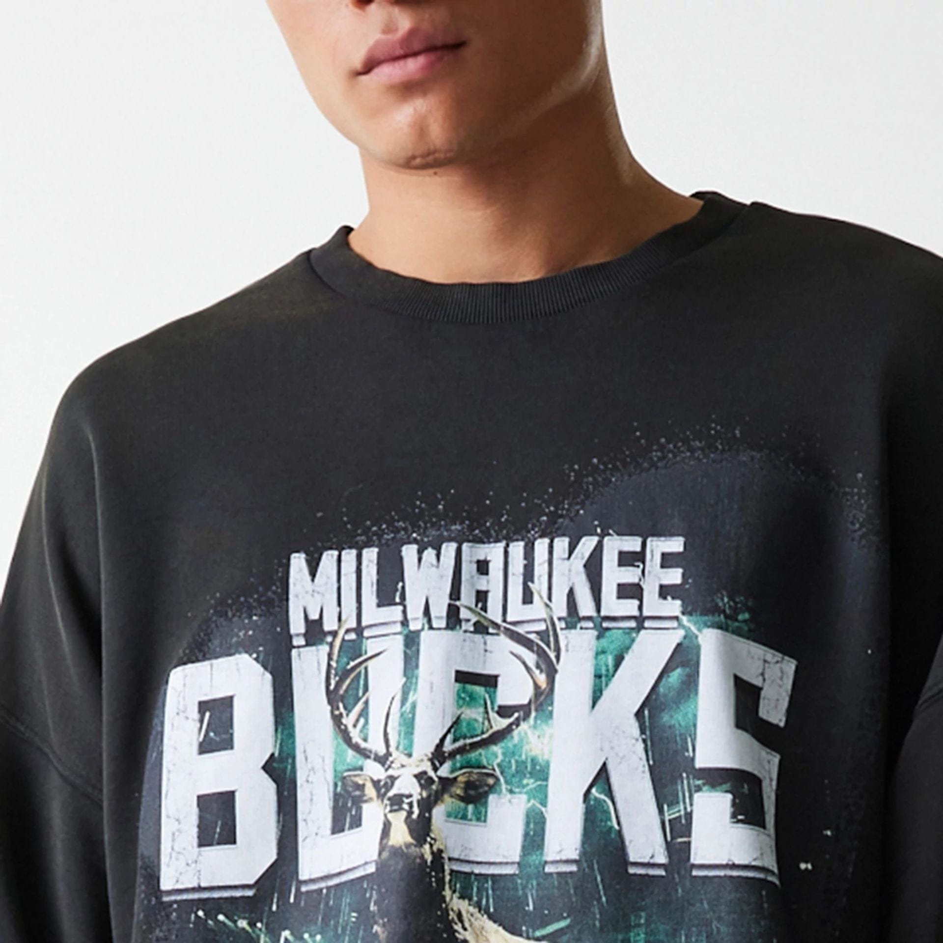 The Male model is wearing Milwaukee Bucks NBA Washed Graphic Grey Oversized Crew Neck Sweater 5