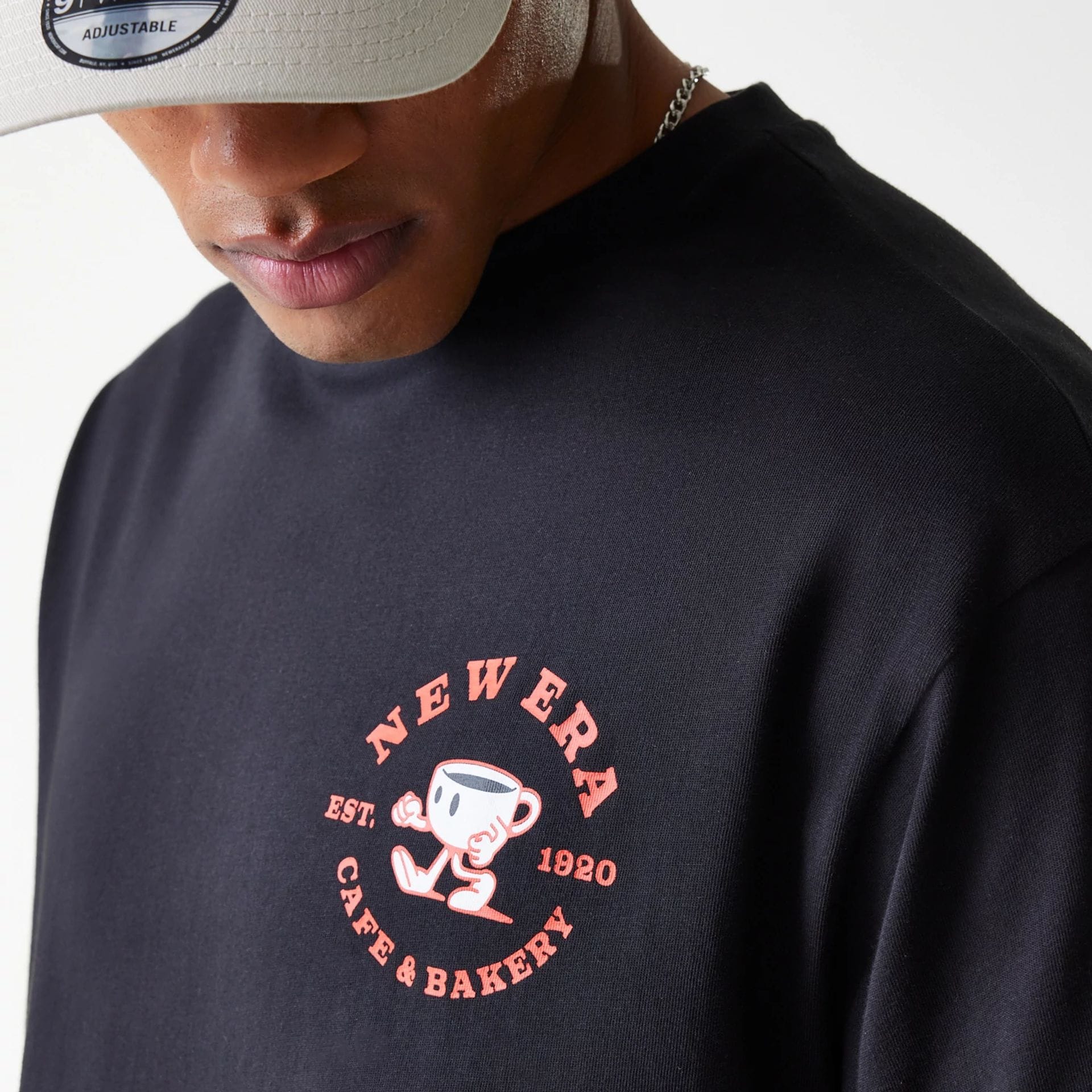 The Male model is wearing New Era Cafe Graphic Black Oversized T-Shirt 6