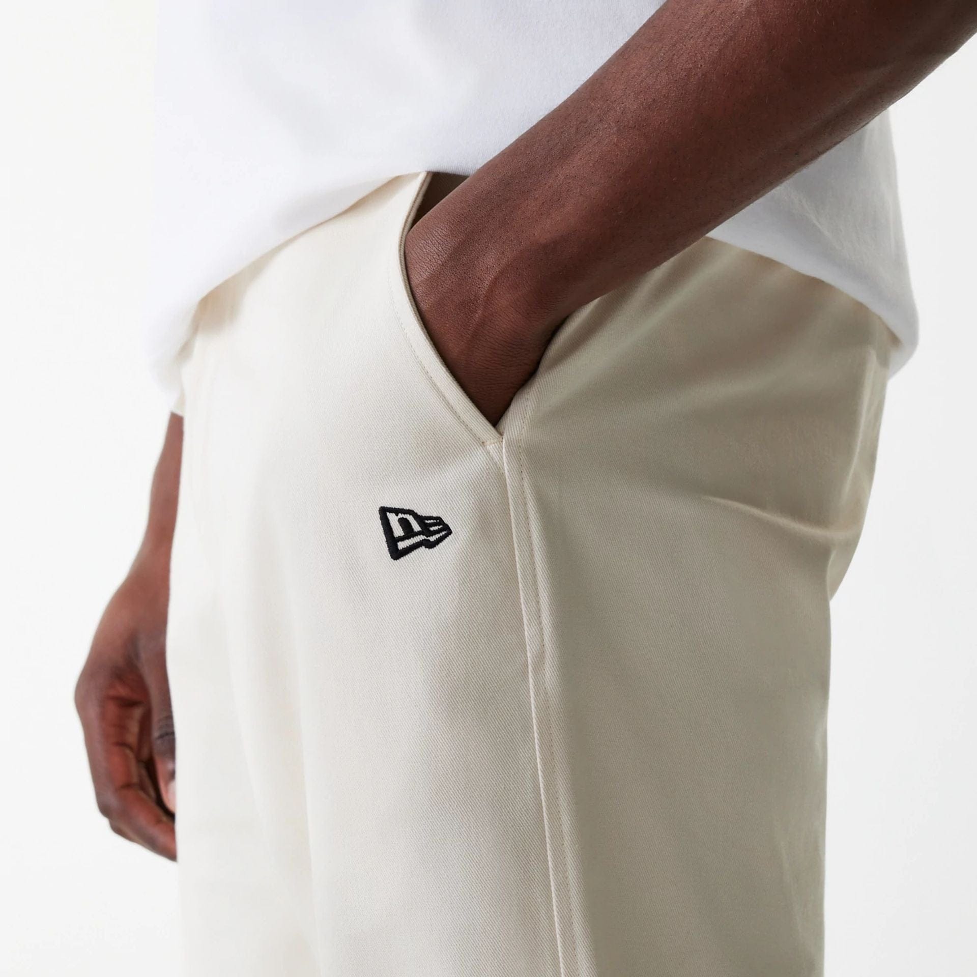 The Male model is wearing New Era Light Beige Chino Trousers 5